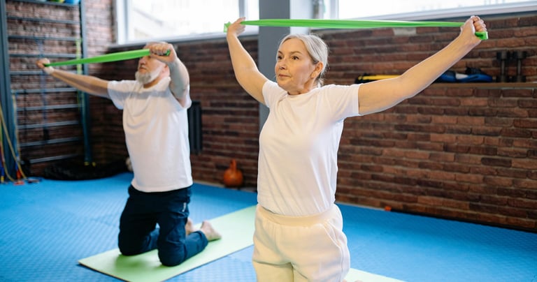 elderly adult male and female exercising with bands