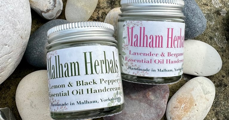 Jars of essential oil hand cream in a natural setting