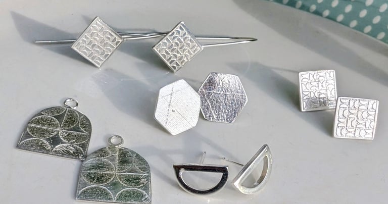 Handmade textured sterling silver earrings in geometric shapes.