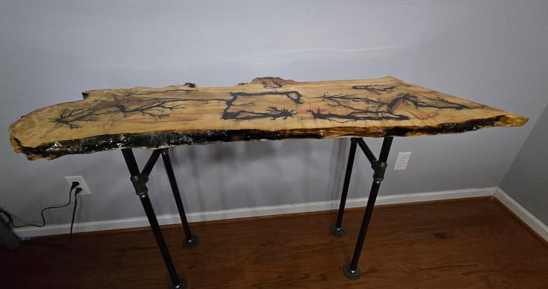 Handcrafted live edge console table wood burning patterns and industrial pipe legs.