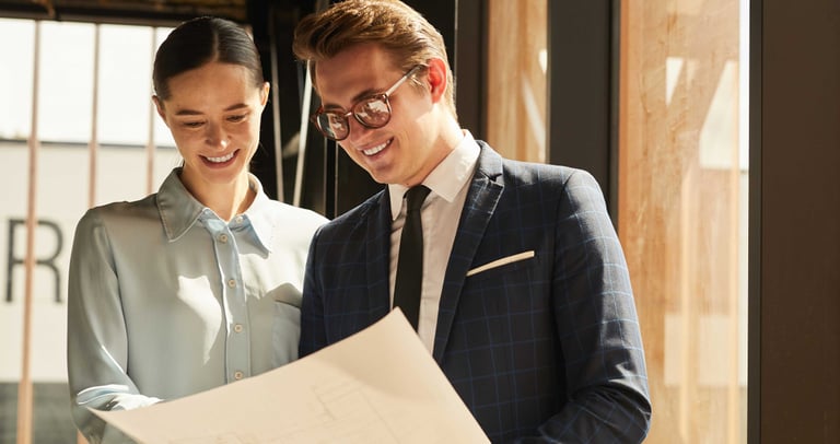 a man and woman in business attire standing in a room