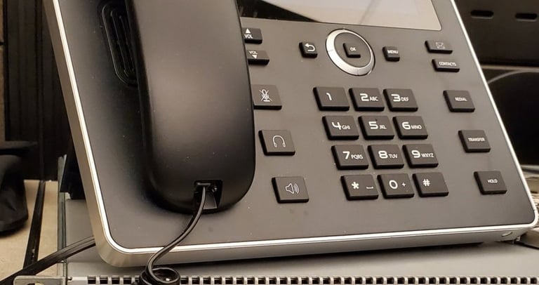 VoIP desk phone on top of a network device