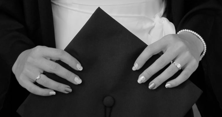 Close-up photo of hands holding a graduation cap