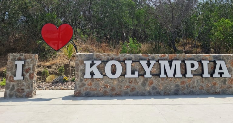 A stone monument reading I Love Kolympia with a red heart icon at the entrance to the Rhodes resort town.
