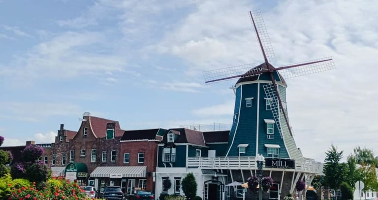 Historic Dutch windmill building and storefronts in a charming downtown village street.
