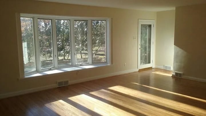A finished interior painting job room with a window and a large window