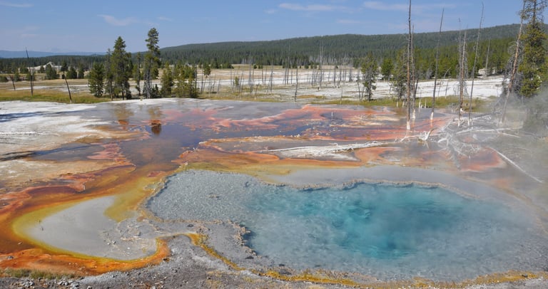 a large geothermal blue pool in yellowstone national park