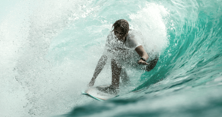 un hombre en una tabla de surf sobre una ola