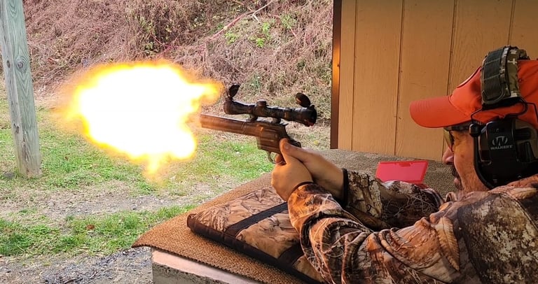 A hunter firing a scoped revolver at a shooting range with a large orange muzzle flash.