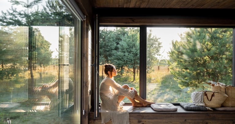 Femme paisible dans son salon en bois, évoquant le feng shui
