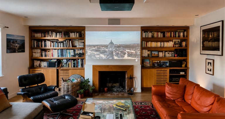 Salon privé transformé en espace cinéma avec vidéoprojecteur plafond et écran de projection