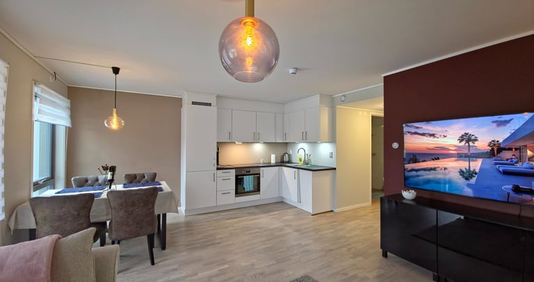Modern open-plan living area with modern ceiling lamp flat screen TV on the bourgundi colored wall