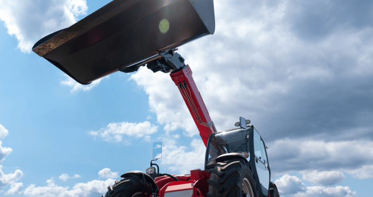 Light front loaders for small tractors lifting a heavy-duty bucket attachment.
