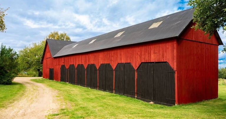 Old wooden barn painted with breathable heritage paint, showing natural aging without peeling or cracking