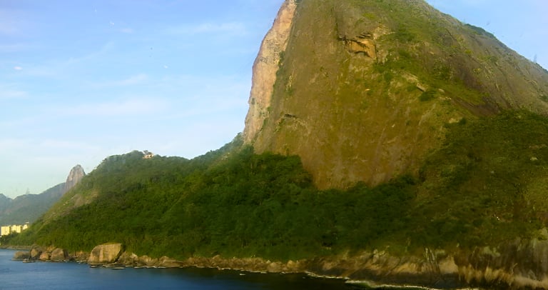 Navio de cruzeiro chegando ao Rio de Janeiro com o Pão de Açúcar ao fundo.