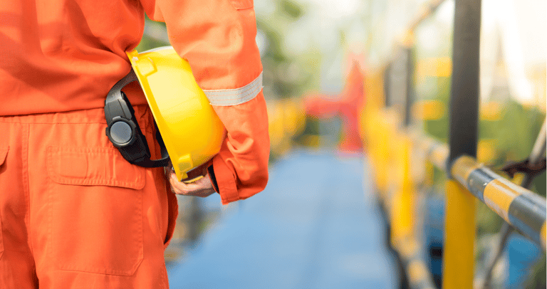 Profissional da área de segurança do trabalho com EPI nas mãos.