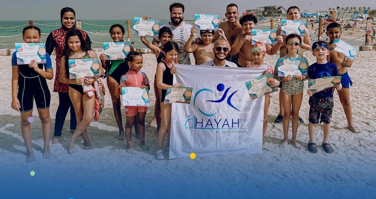 Our students holding certificates at Hayah academy Sport Academy beach swimming camp in the UAE.