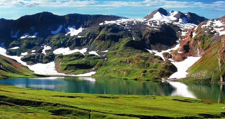 a mountain scene with Ansoo lake and mountains in the background