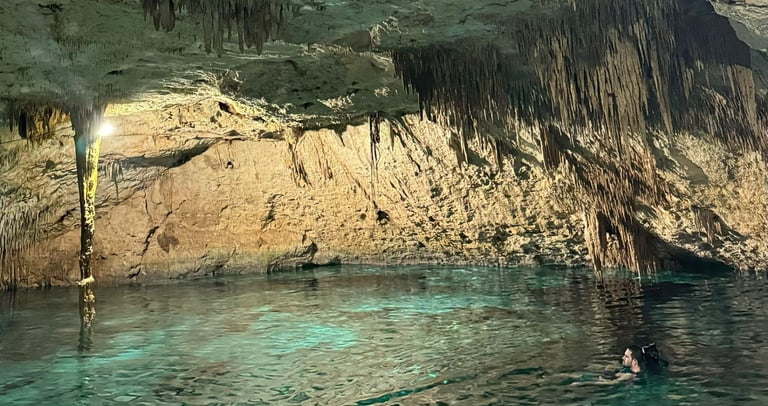 a person swimming in a cave with a person in the water