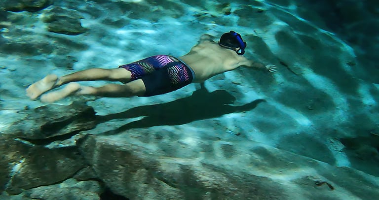 a man swimming in a pool with a snorh