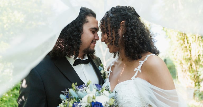 Un couple de mariés sous un voile blanc, mariage au Puy Saint bonnet