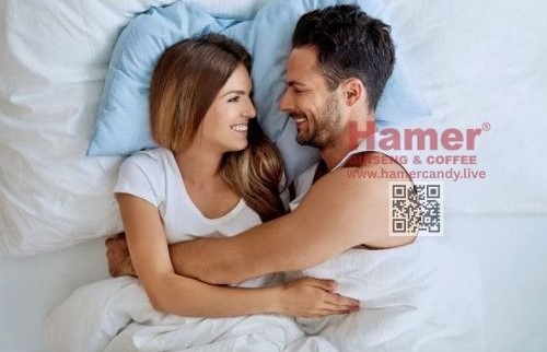 a man and woman are smiling and hugging in bed hamer candy