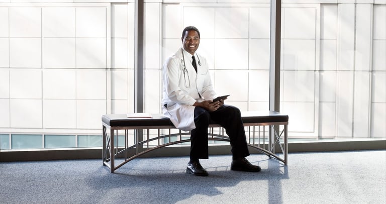 a man in a white lab coat sitting on a bench