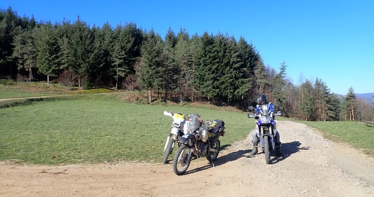 two motorcycles parked on a dirt road