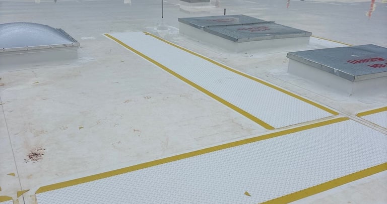 Wide-angle view of a clean commercial TPO roof system with designated yellow-bordered walkway pads, 