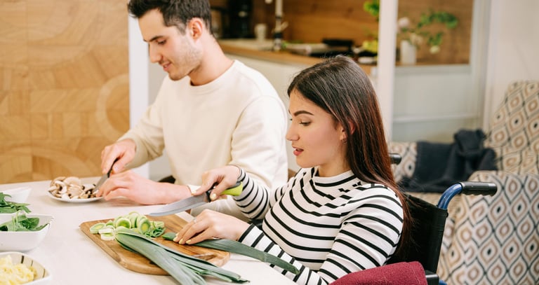 Support worker helping a participant prepare food in the kitchen