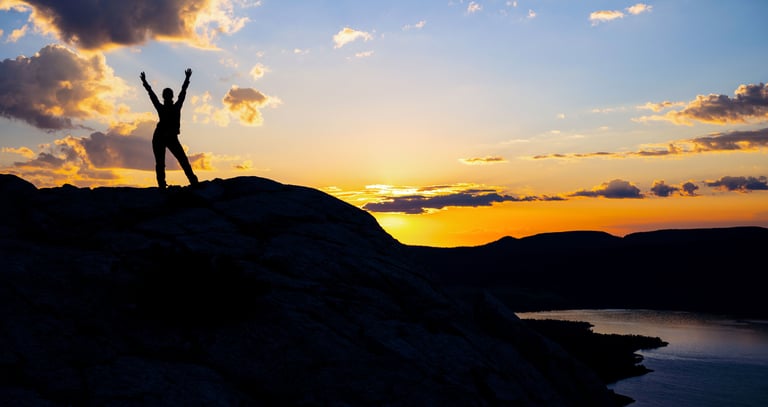 Hiker silhouette at dawn on Bear’s Hump overlooking Upper Waterton Lake.