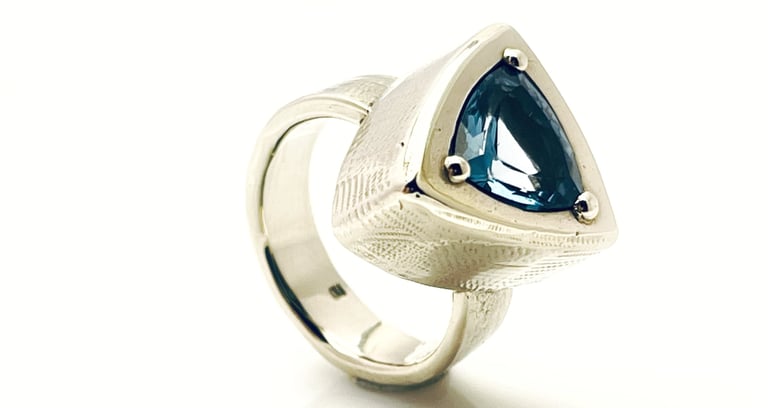a ring with a blue TOPAZ and white GOLD