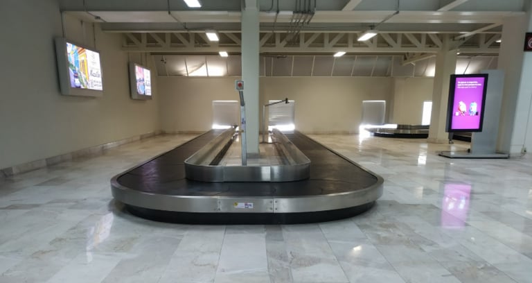 Carrusel de reclamo de equipaje en aeropuerto para la entrega eficiente de maletas a pasajeros.