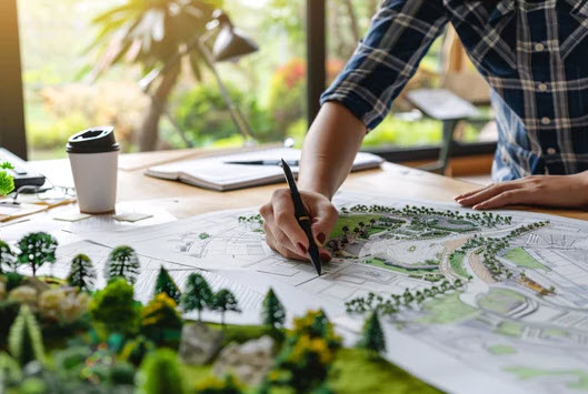 a man is working on a landscape design in a home office