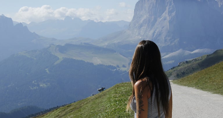 Magui fotografiada de espaldas viendo una montaña soleada