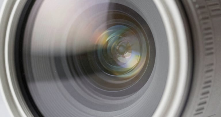 Abstract photography of light reflecting on a lens, creating subtle flares, clean and modern aesthetic, white and light gray tones, professional style.
