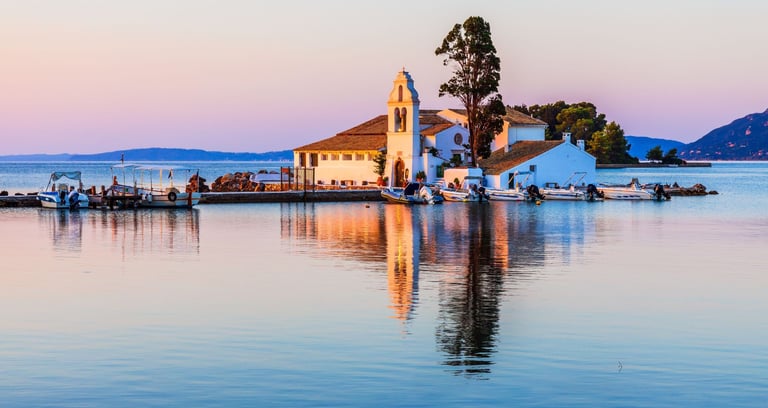 Vista do passeio de barco em Corfu, com a igreja no mar ao fundo e barcos ancorados no pier.