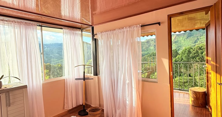 Habitación con cama doble, grandes ventanas con balcón