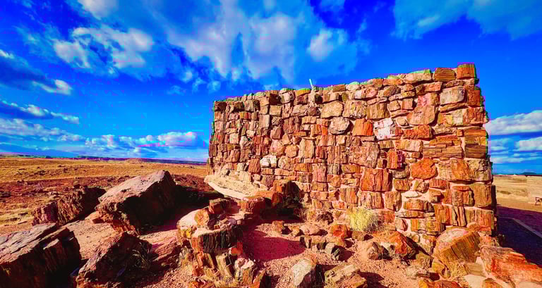 Ancient Agate House ruins built from petrified wood at Petrified Forest National Park under a bright blue sky.