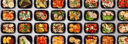 A wide variety of healthy meal prep containers with balanced salads, proteins, and fresh fruit.