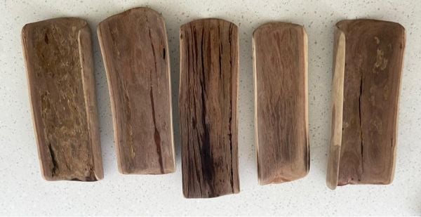 5 hardwood coolamons on a table