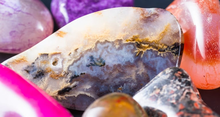 Ágata pulida y cristales de cuarzo en tonos morados, rosados y matices naturales de la tierra