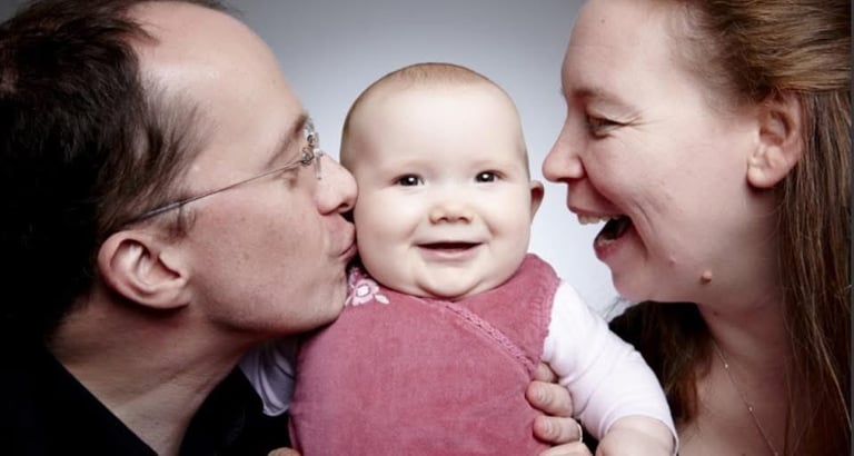 smiling man and woman with baby girl 