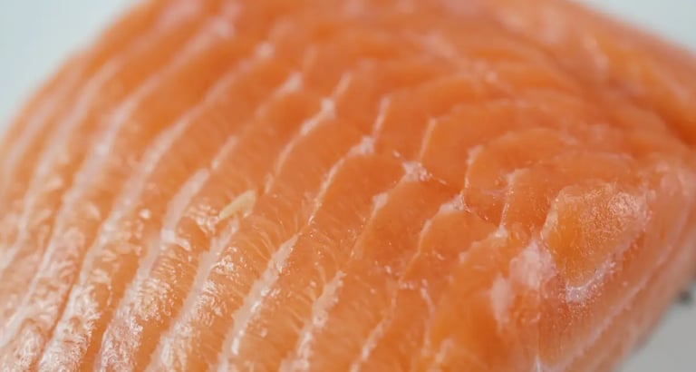 a orange fleshed salmon fillet on white background