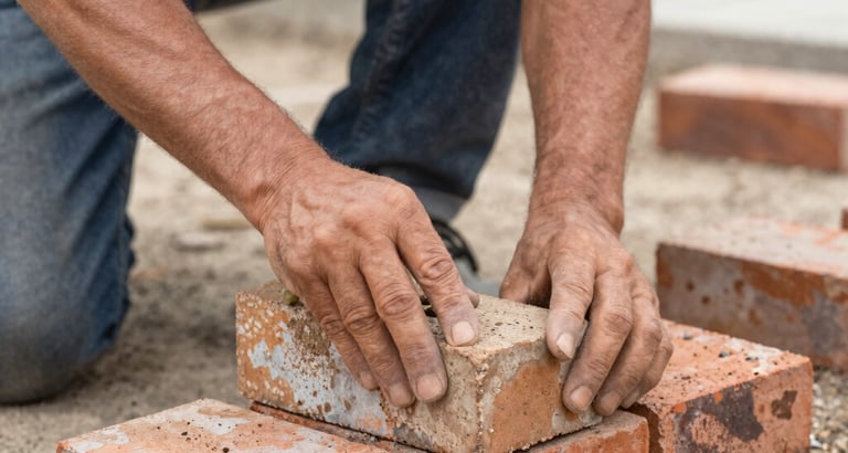 Masonry contractor laying bricks for retaining wall