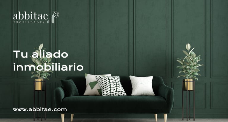 Un sofá verde con almohadas y cojines frente a una pared verde.