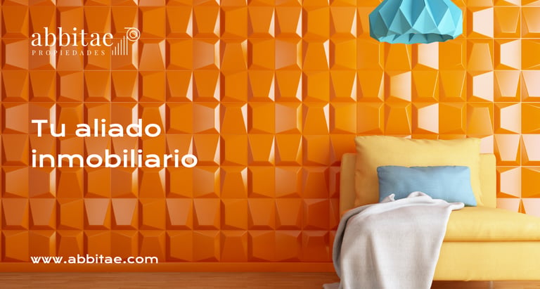Una silla con una manta y una lámpara delante de una pared color naranja