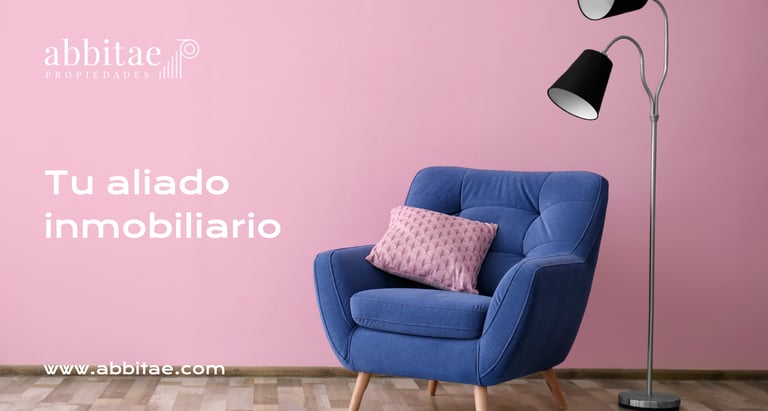 Una silla azul con una pared rosa y una lámpara.