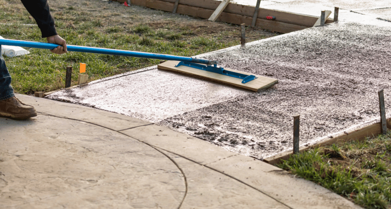 a man is using a blue broom to clean the concrete