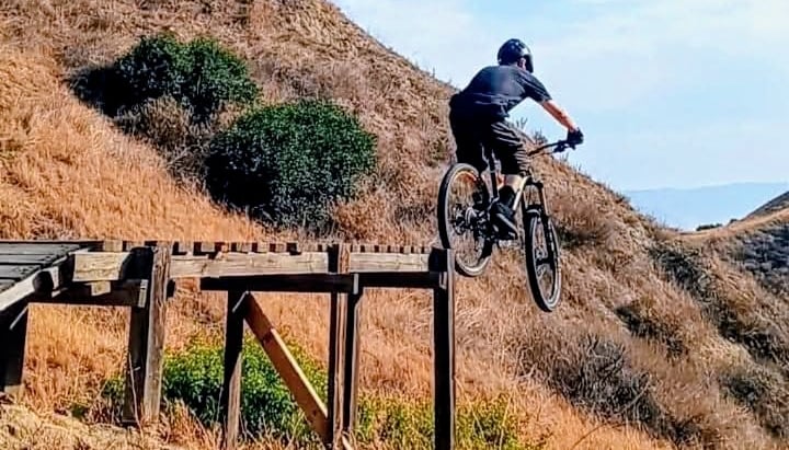 mountain biker riding off ladder drop